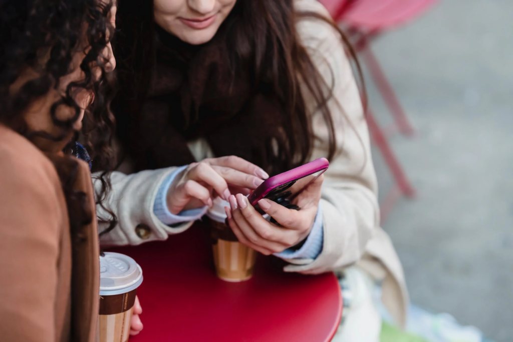 dos chicas mirando el movil en un bar